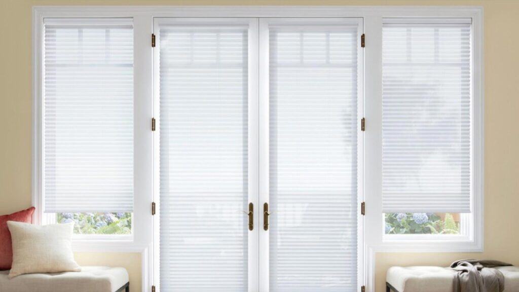 Bright white window blinds on a large glass door and side windows, allowing adjustable light control, with a cozy sitting area below, showcasing a relaxed, homey environment perfect for relaxation or reading.