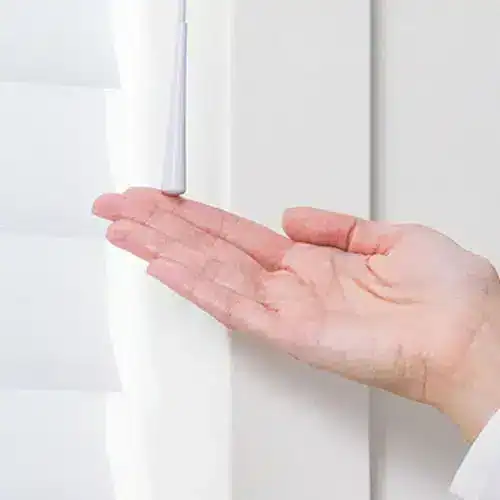 Close-up of a person checking a white door hinge with their palm, ensuring proper alignment and functionality for smooth operation.