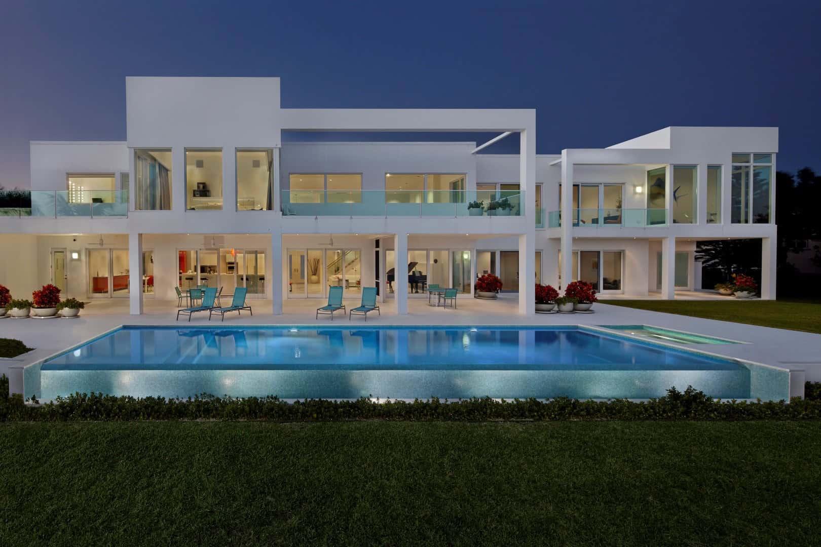 Modern Florida home with sleek architecture, large glass windows, and a swimming pool, showcasing upscale residential construction.